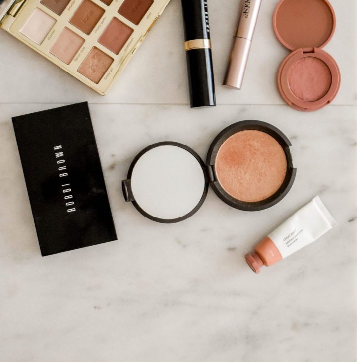 photo of assorted makeup products on gray surface